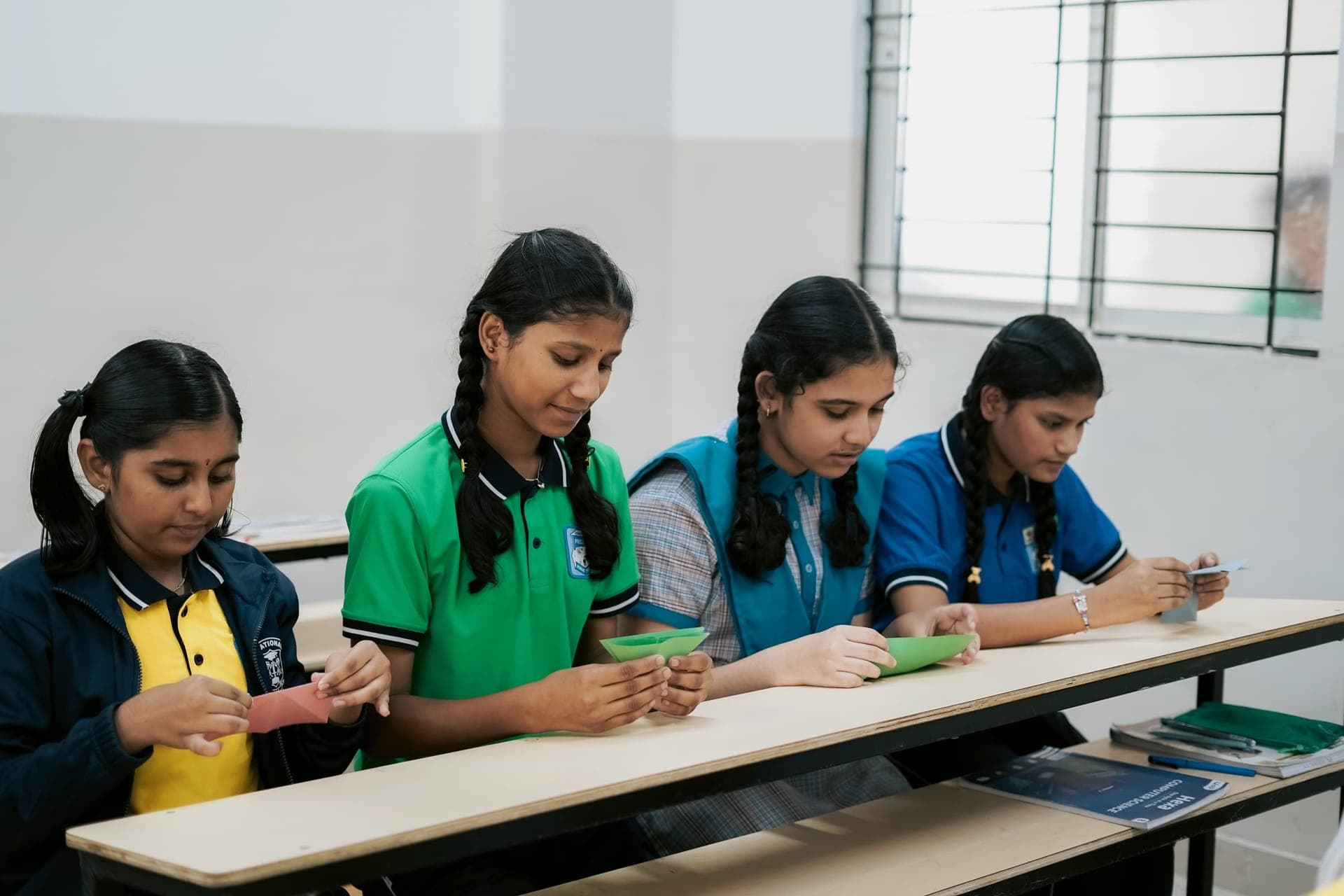 Students folding paper together during a school event